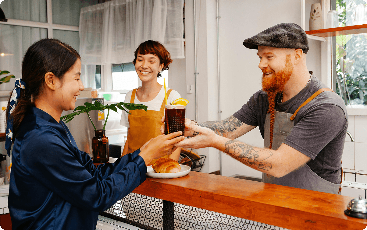 Restaurant owner serving craft beer to a happy customer
