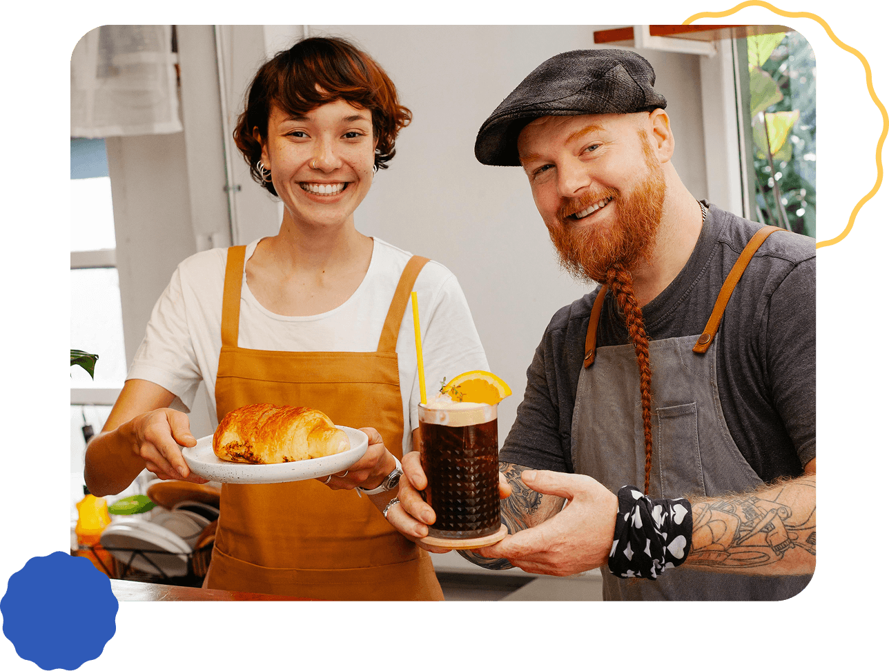 Smiling restaurant owner couple in aprons holding food